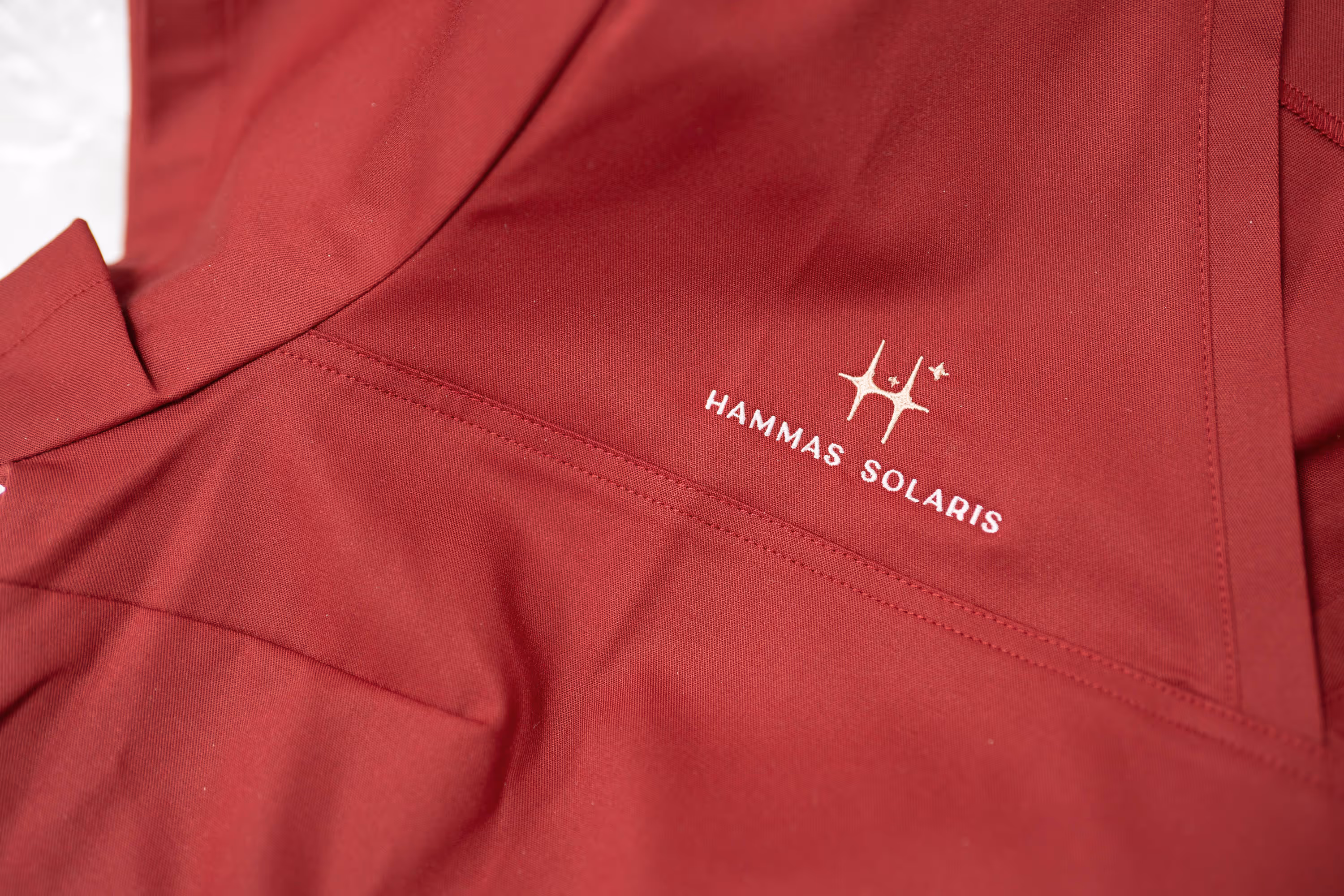 Punainen paita, jossa on valkoinen logo "HAMMAS SOLARIS" ja tähdet.